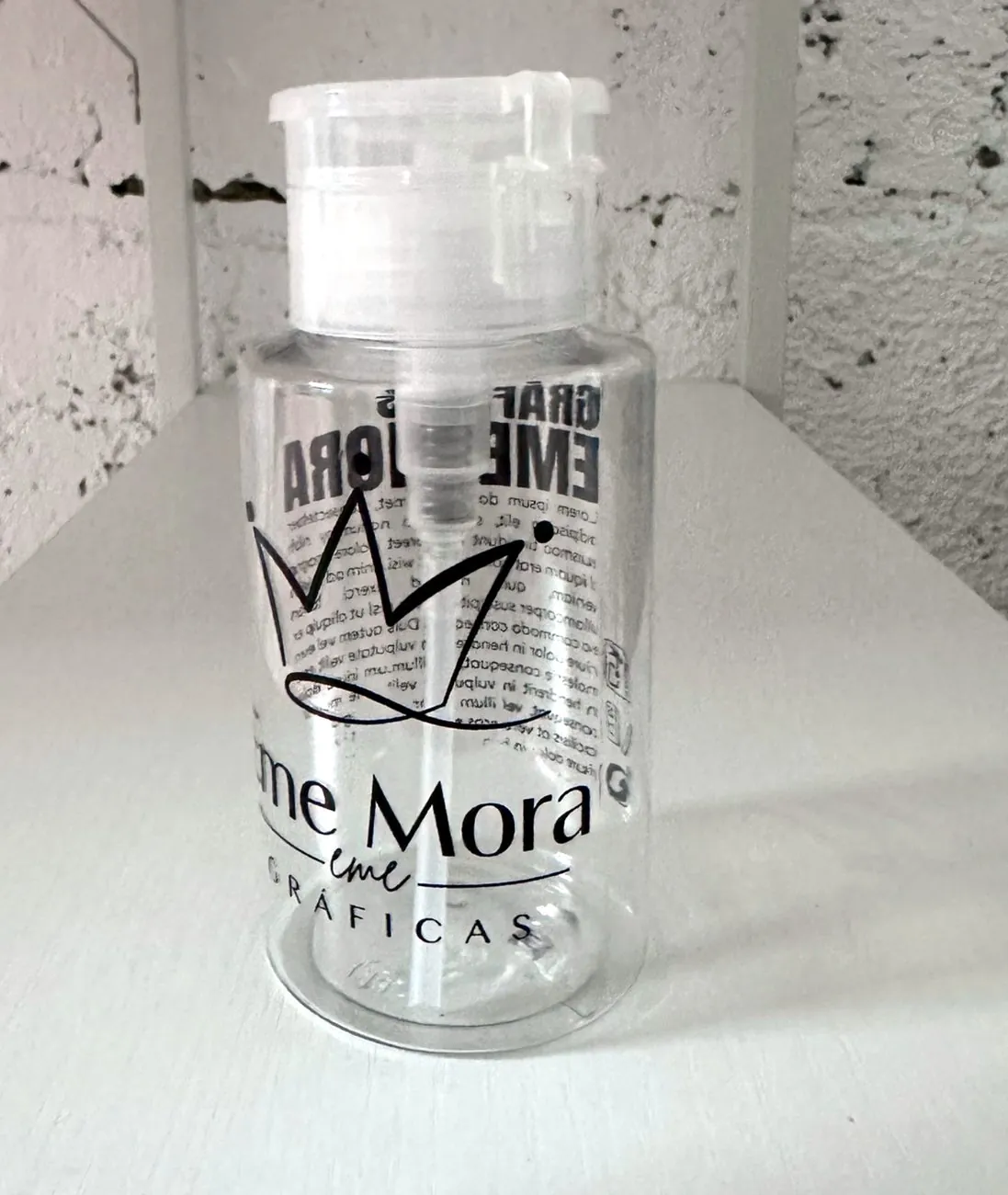 Bote dosificador de PET transparente con logo y texto fino impresos en negro